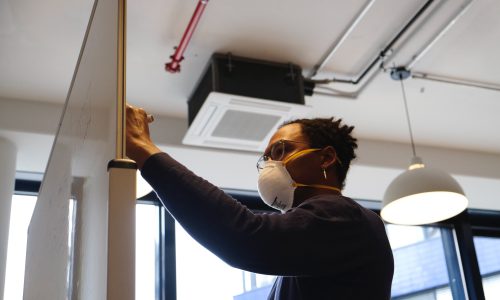 man writing on white board