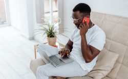 man on his phone and laptop